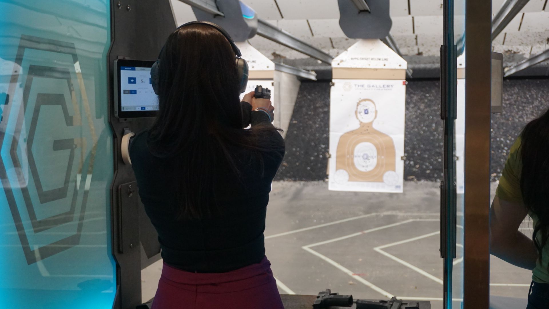 Woman practicing firearm skills at indoor range during Avenir Consulting safety training.