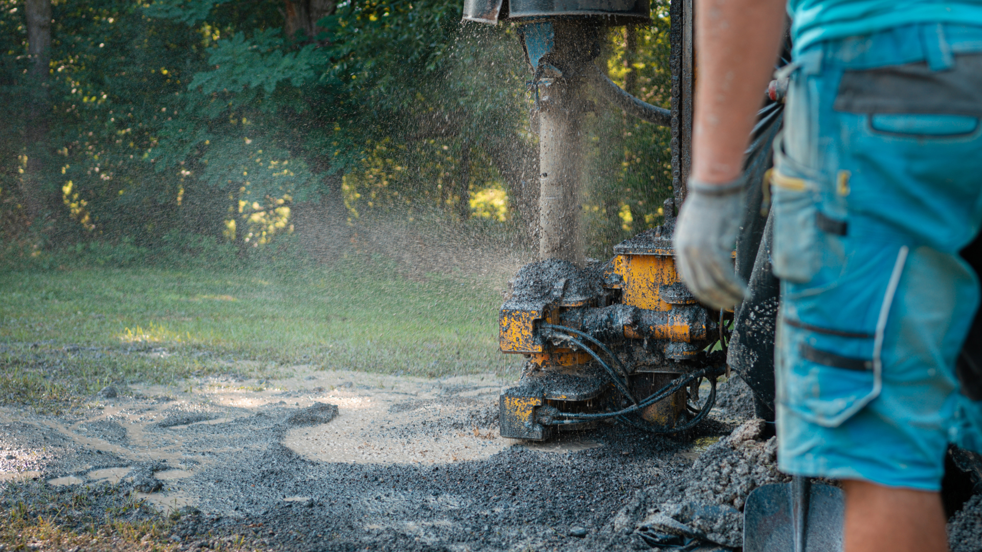 A man is using a machine to dig a hole in the ground.