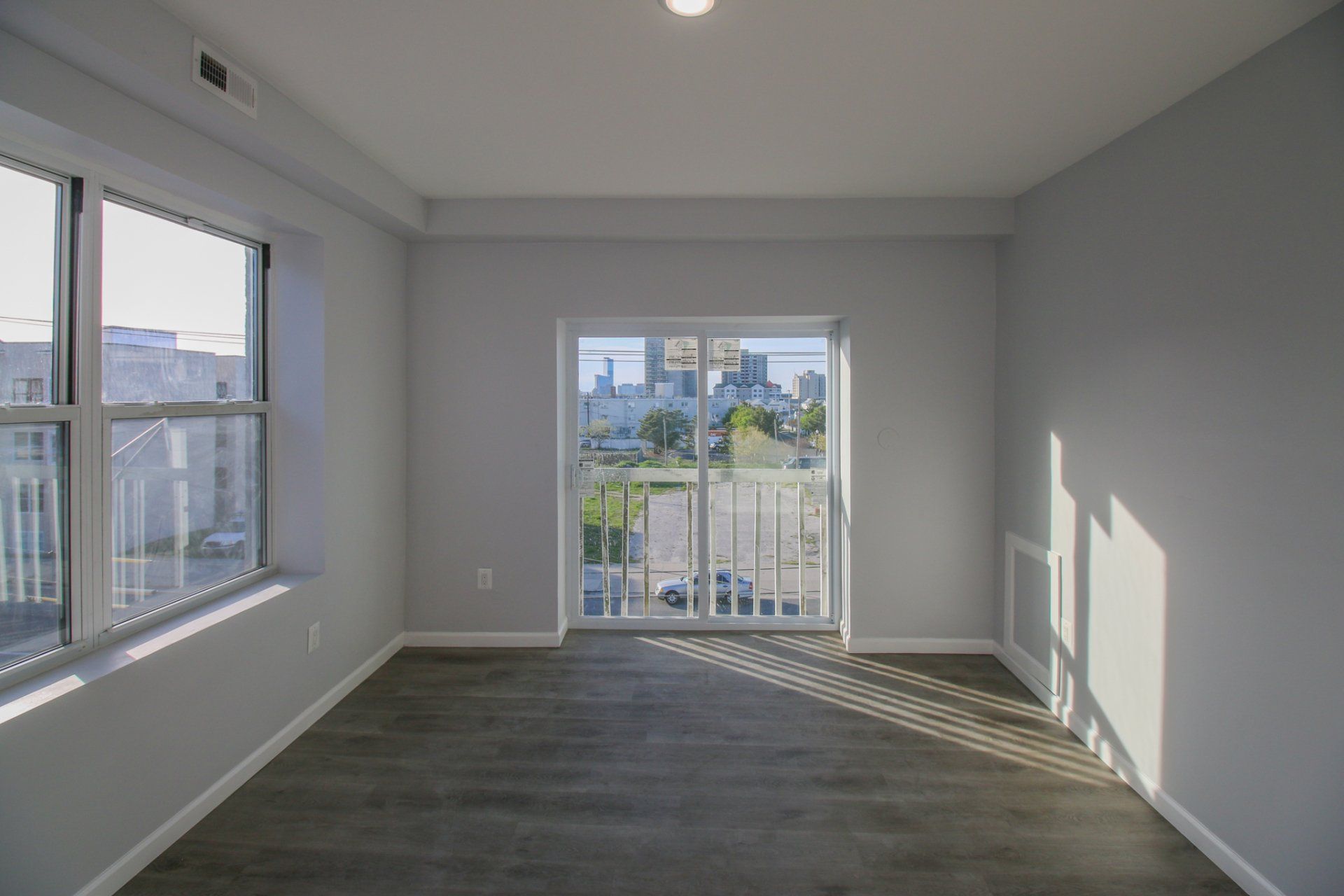 Updated living room with grey flooring and large window.