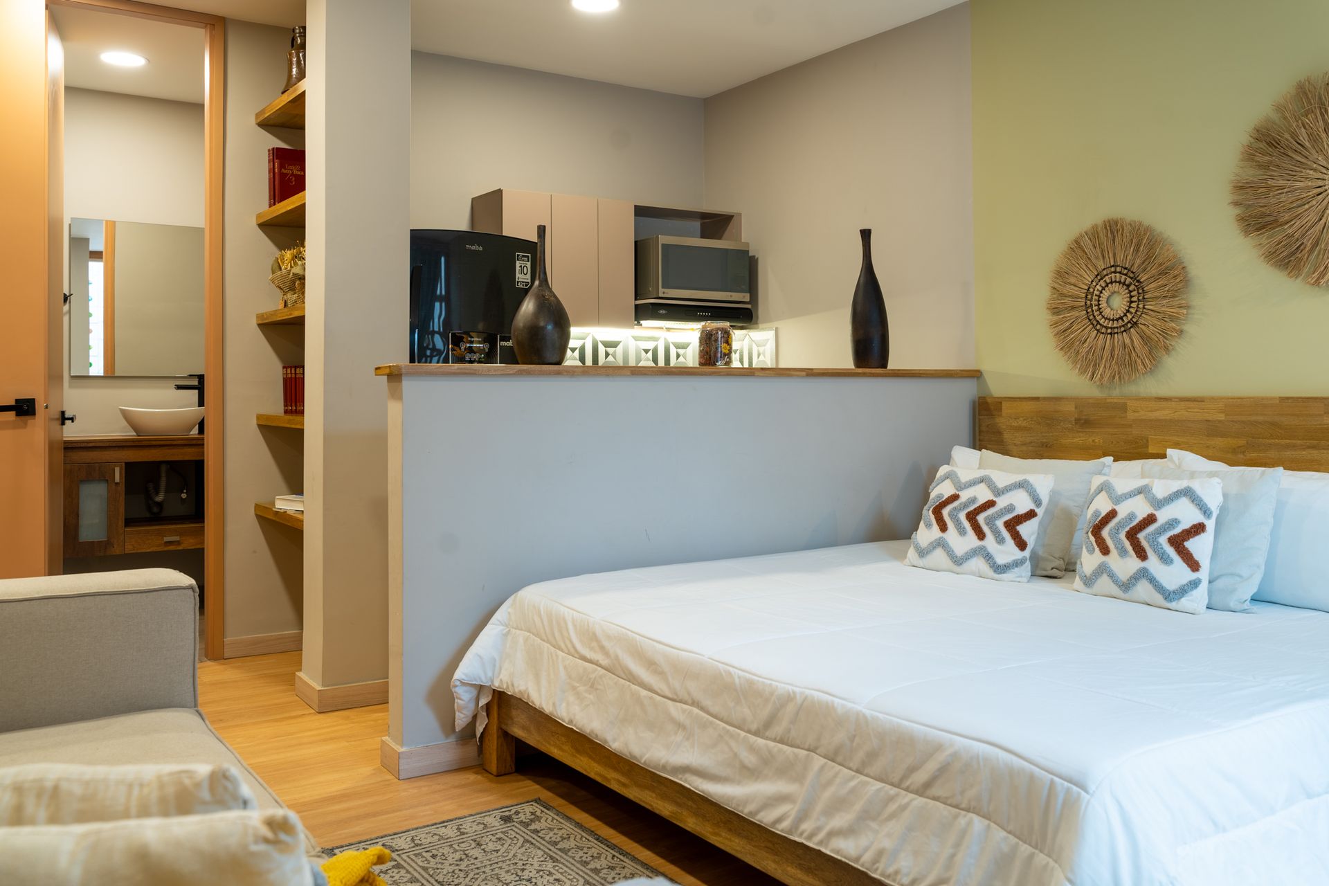 Acogedor estudio con cama, cocina americana y baño a la vista. Colores neutros.