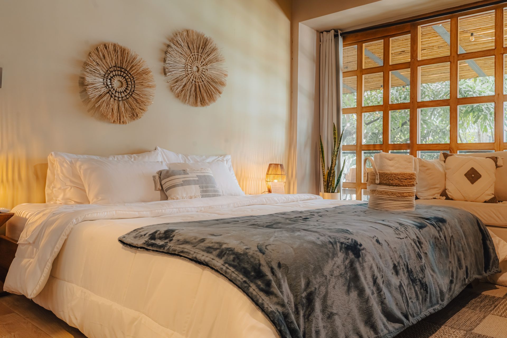 Dormitorio con cama grande, adornos de pared y ventana con luz natural.