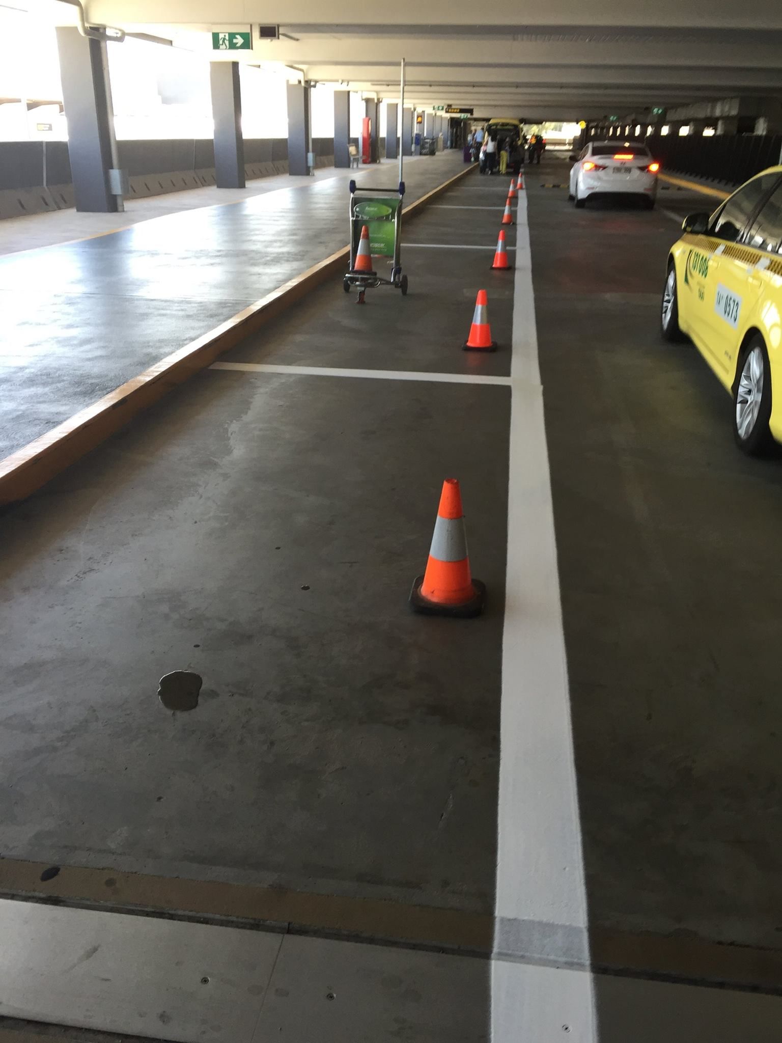 A yellow car is parked in a parking garage