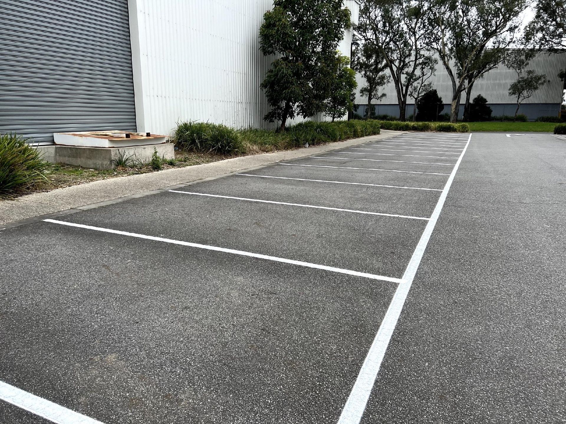 A parking lot with white lines on it in front of a building.