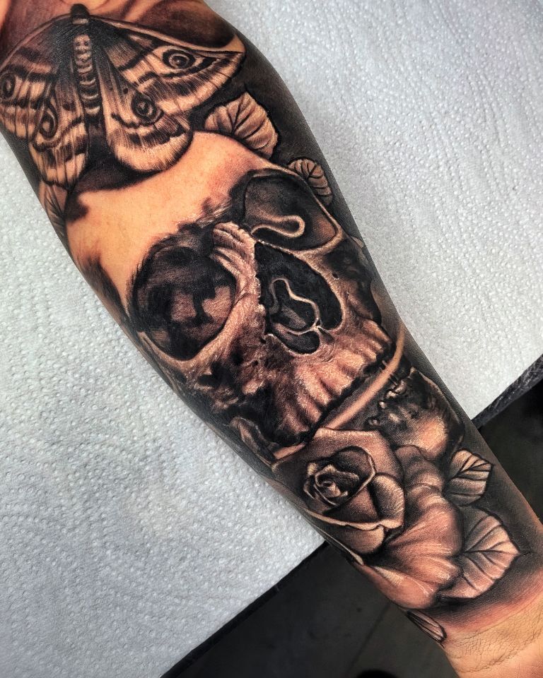 Dark Realistic tattoo of a skull, a moth blending into a rose, Made in Aarau by Costa