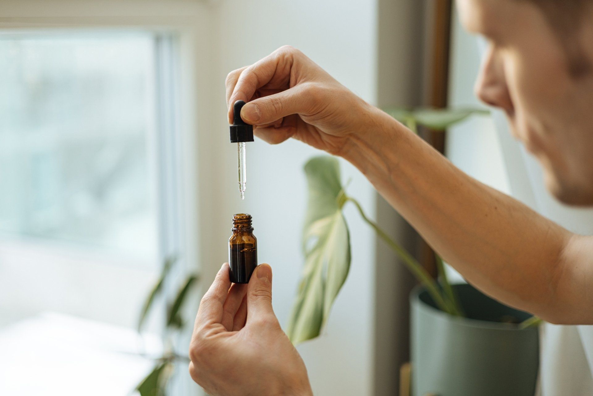 Hand holding pipette of Hemp oil.