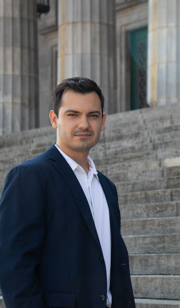 Una mujer con cabello largo lleva un suéter rosa y sonríe.