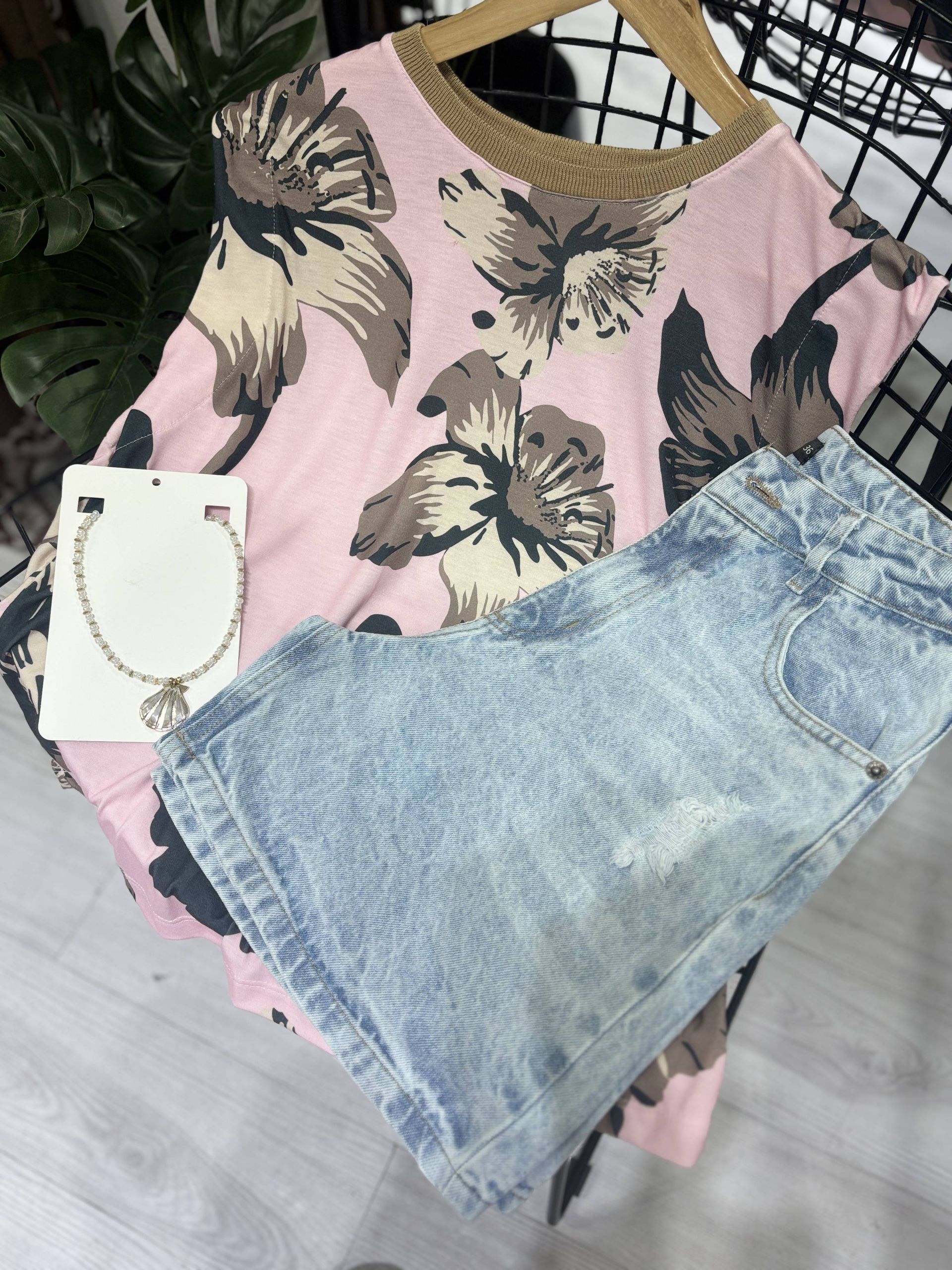 Unos pantalones cortos vaqueros de lavado claro con detalles desgastados cuelgan delante de un espejo.