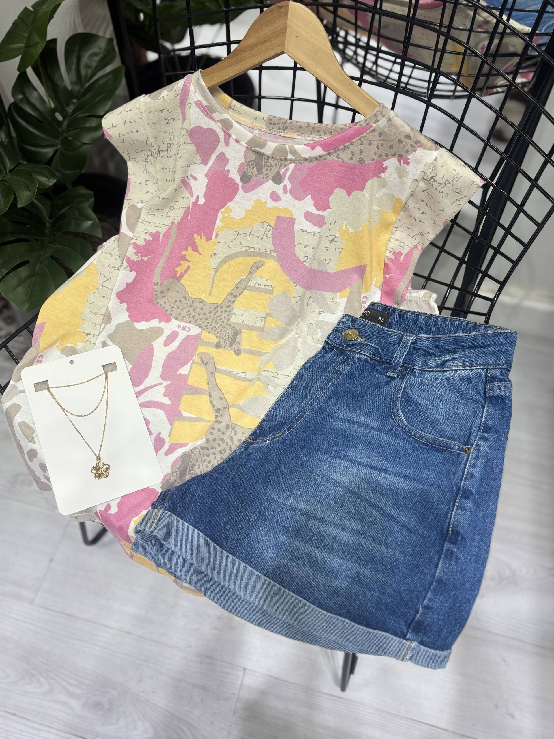 Conjunto con blusa estampada, shorts de mezclilla y collar.