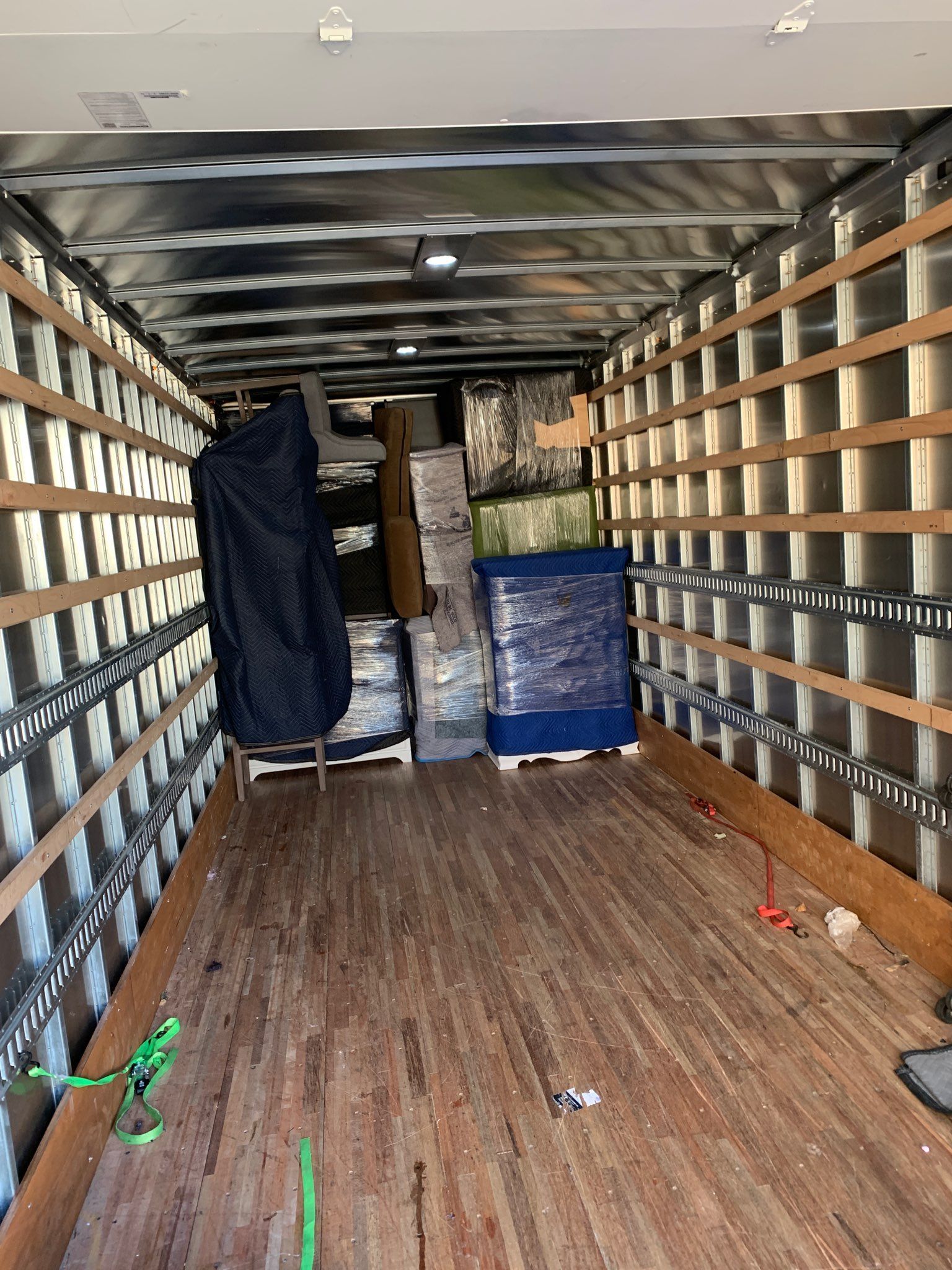 The inside of a moving truck filled with boxes and a piano.