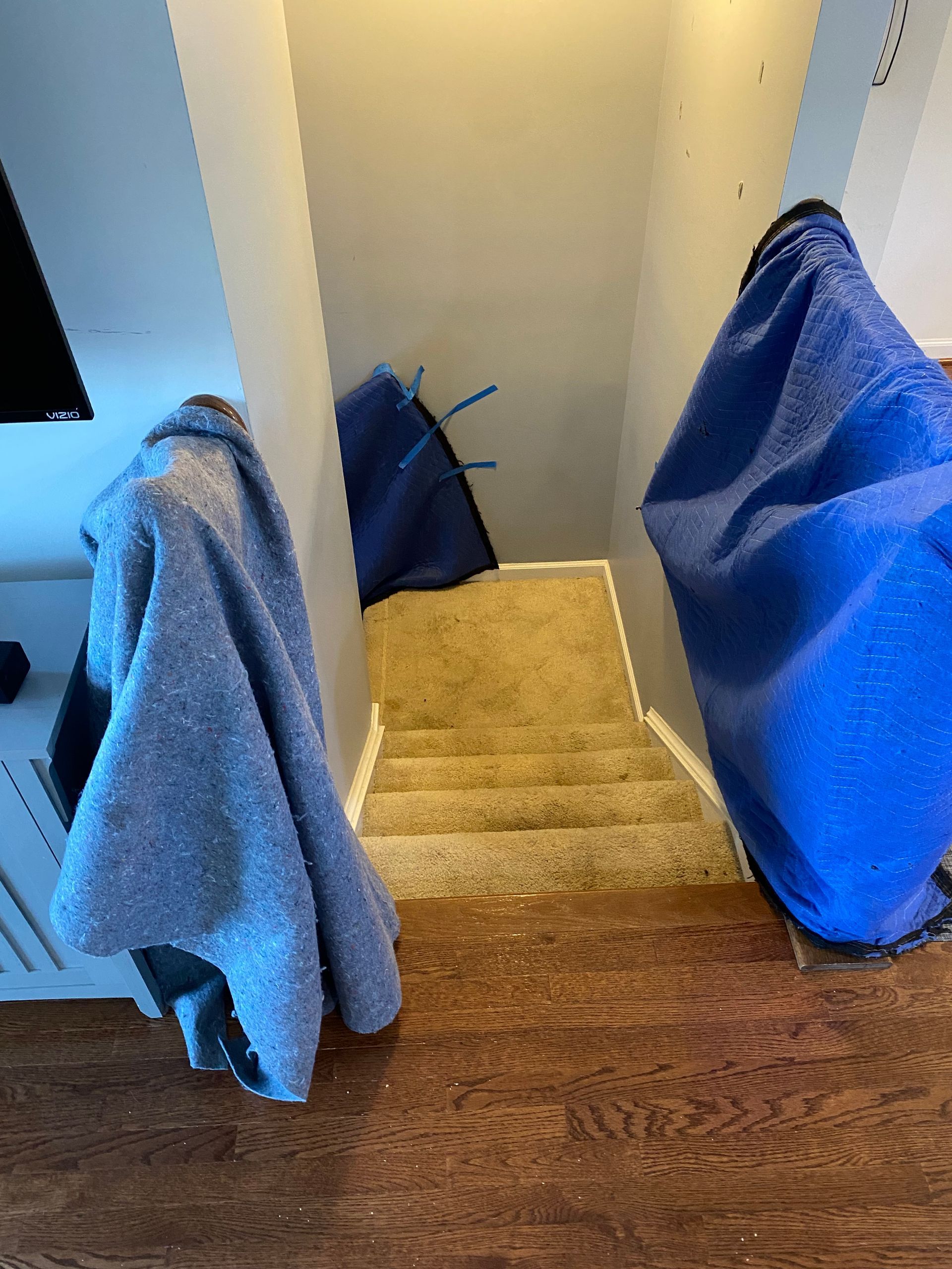 A blue blanket is covering the stairs in a house.
