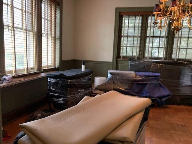 A living room with a piano and a chandelier