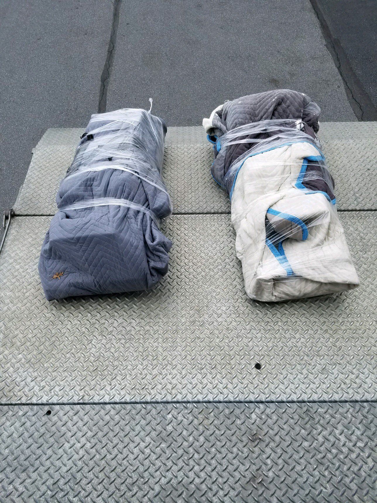 Two towels wrapped in blankets are sitting on top of a metal surface.