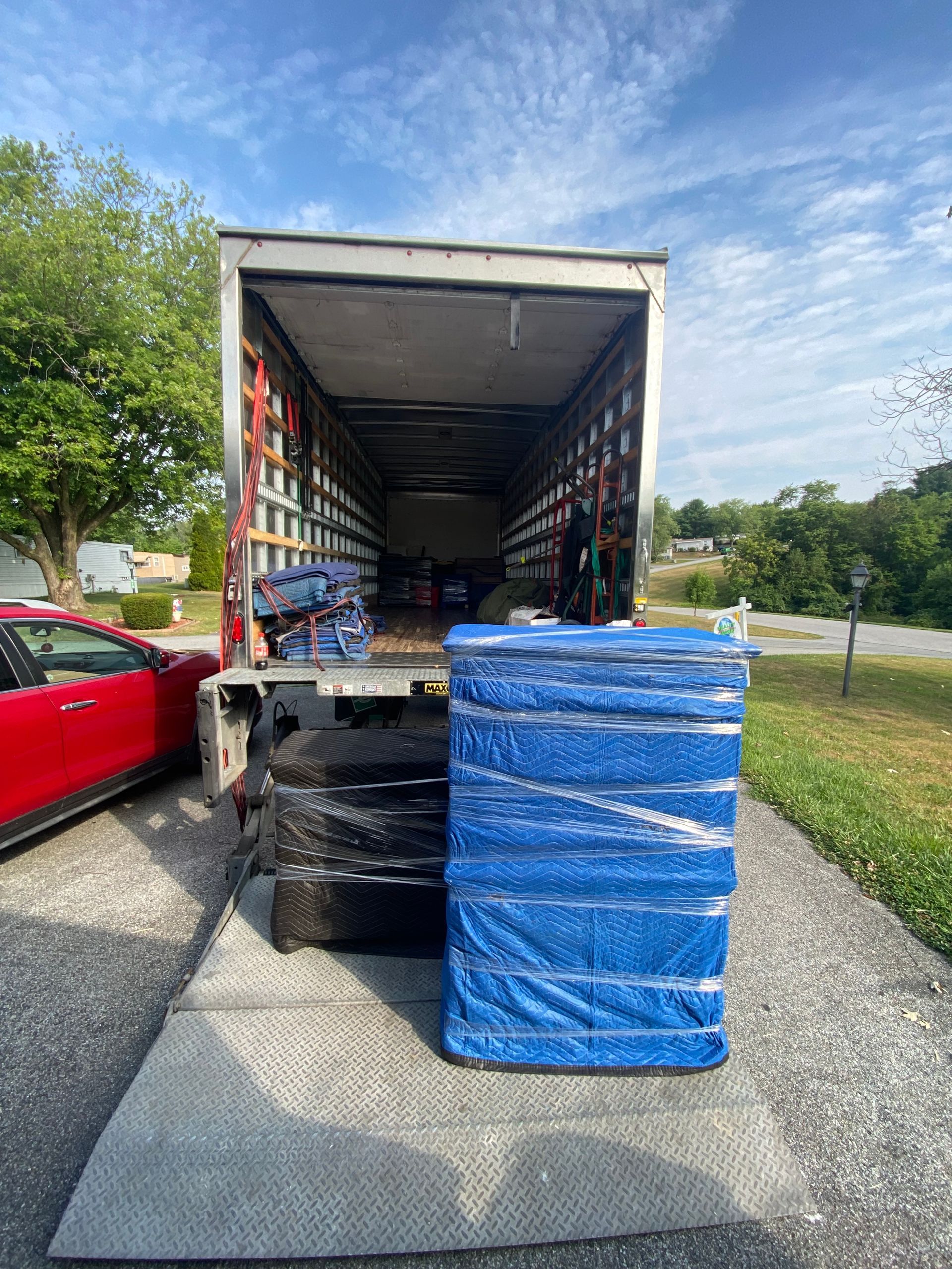 A truck is loaded with a stack of tires and a mattress.