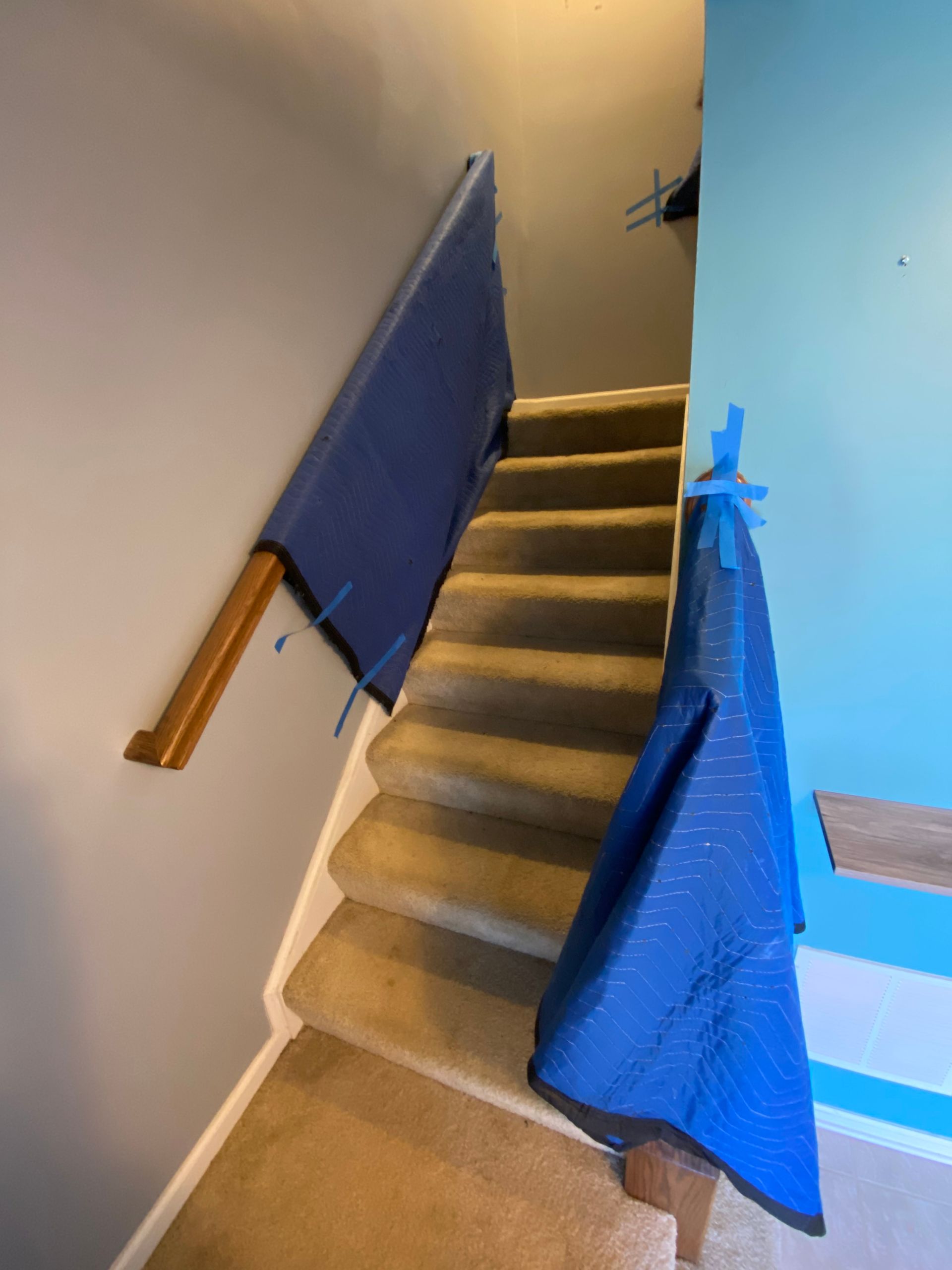A blue tarp is covering the stairs in a house