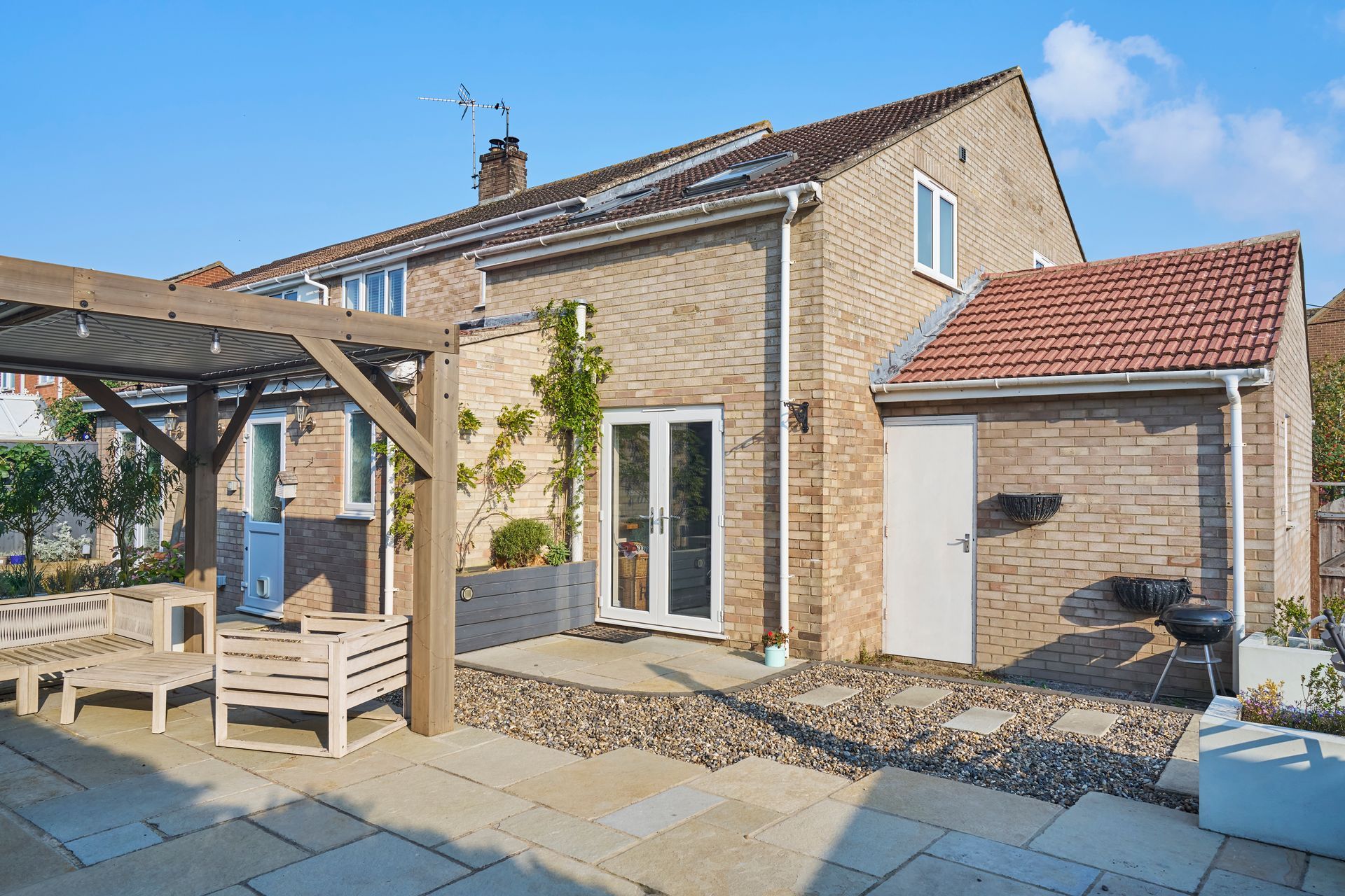 A brick house with a patio and a pergola in front of it.