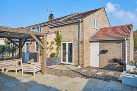 A brick house with a patio and a pergola in front of it.