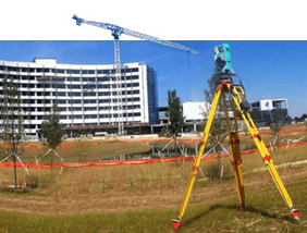 a tripod is sitting in a field in front of a building under construction .