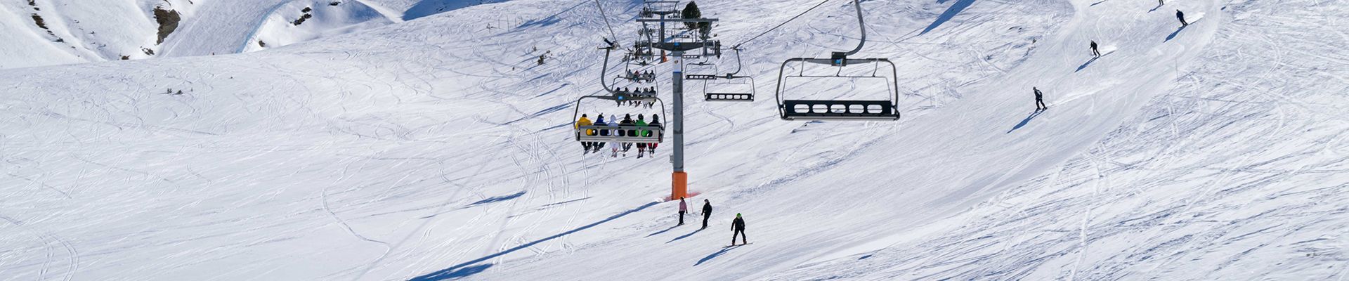 Esquiadores utilizando um teleférico em uma encosta nevada.