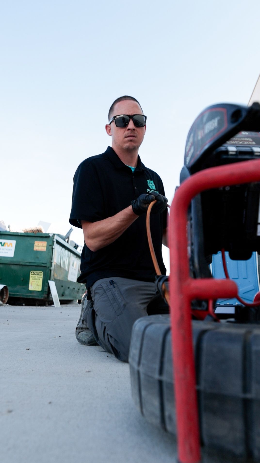 A row of black pipes are being installed in a trench.
