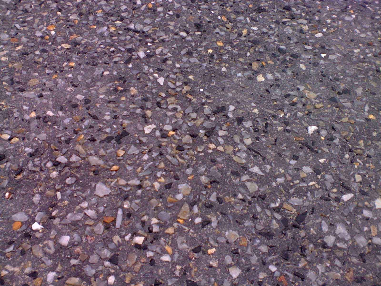 A close up of a concrete surface with a lot of small rocks on it