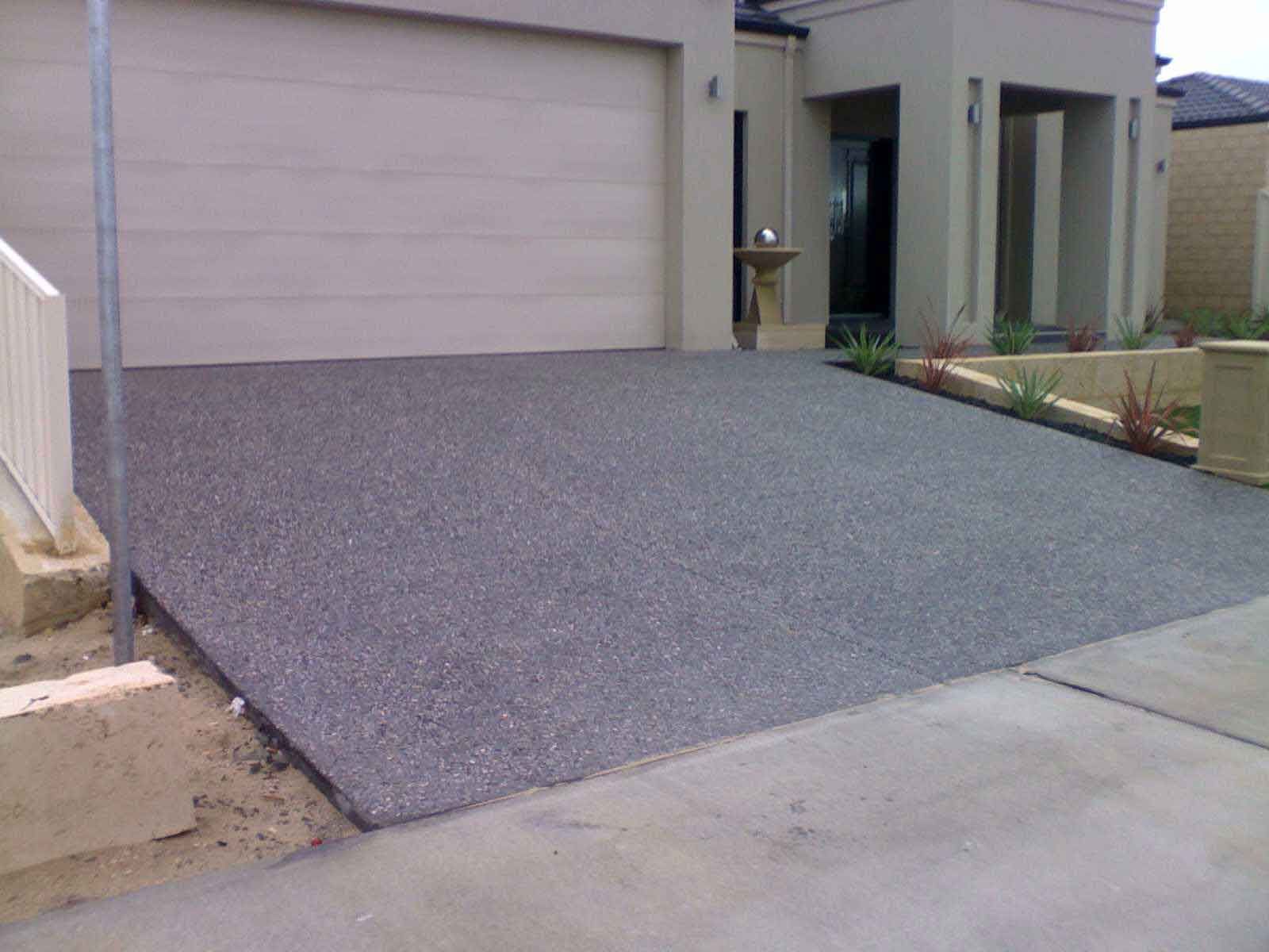 A driveway leading to a house with a garage door