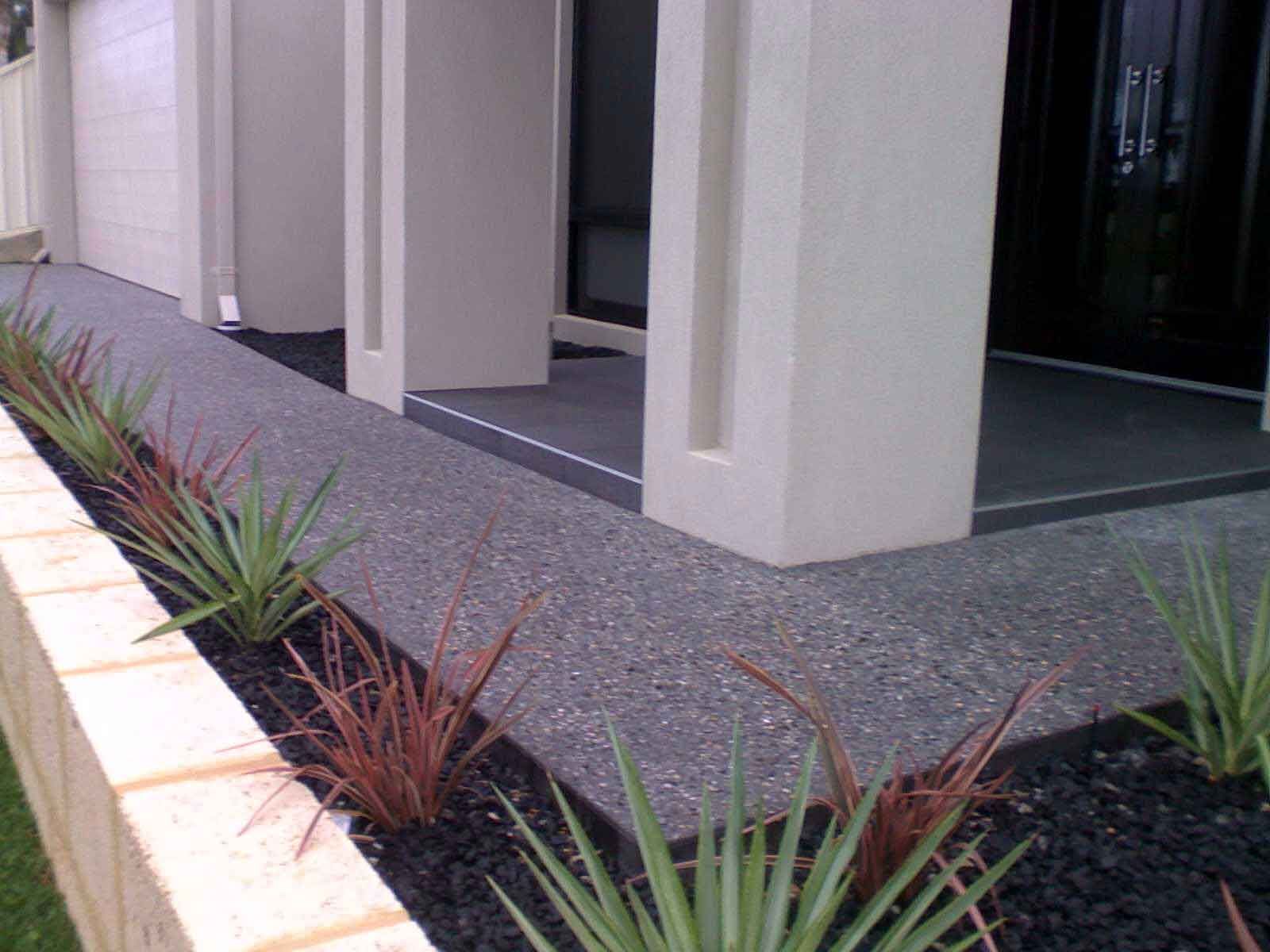 A planter with plants in front of a house