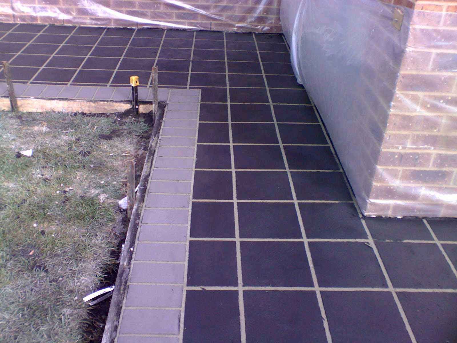 A brick building with a black tile walkway in front of it