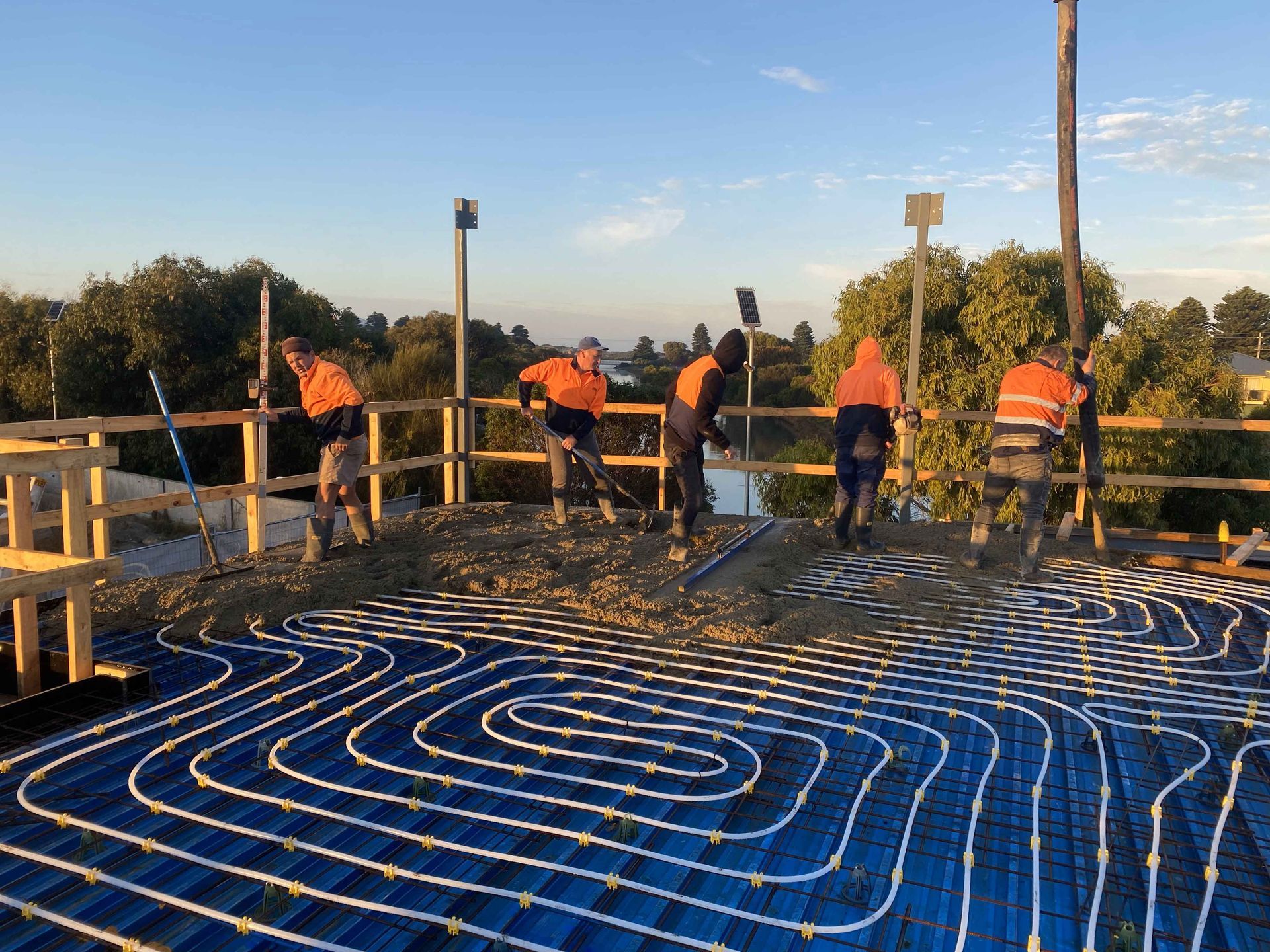 A group of construction workers are working on a blue floor.