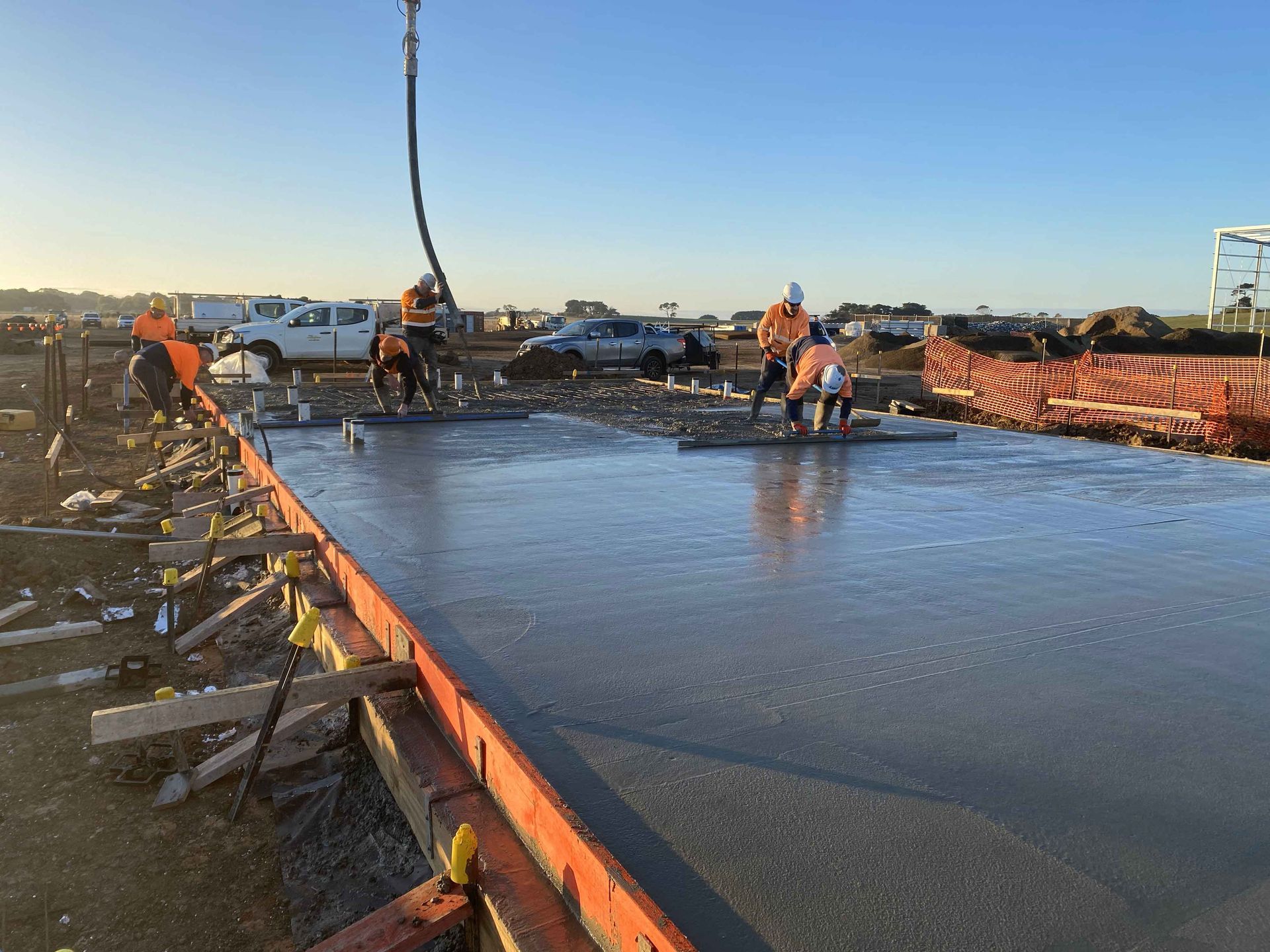 A group of construction workers are working on a concrete floor.
