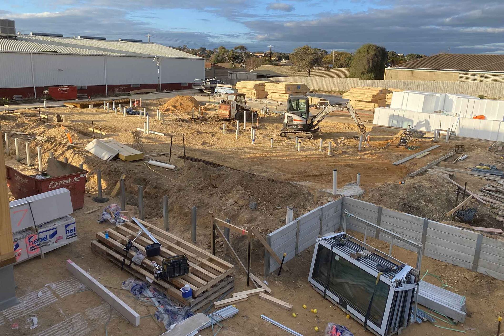 An aerial view of a construction site with a large building in the background.