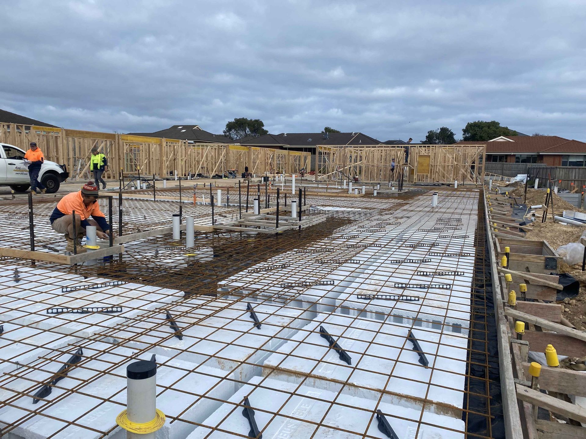 A group of construction workers are working on the foundation of a house.