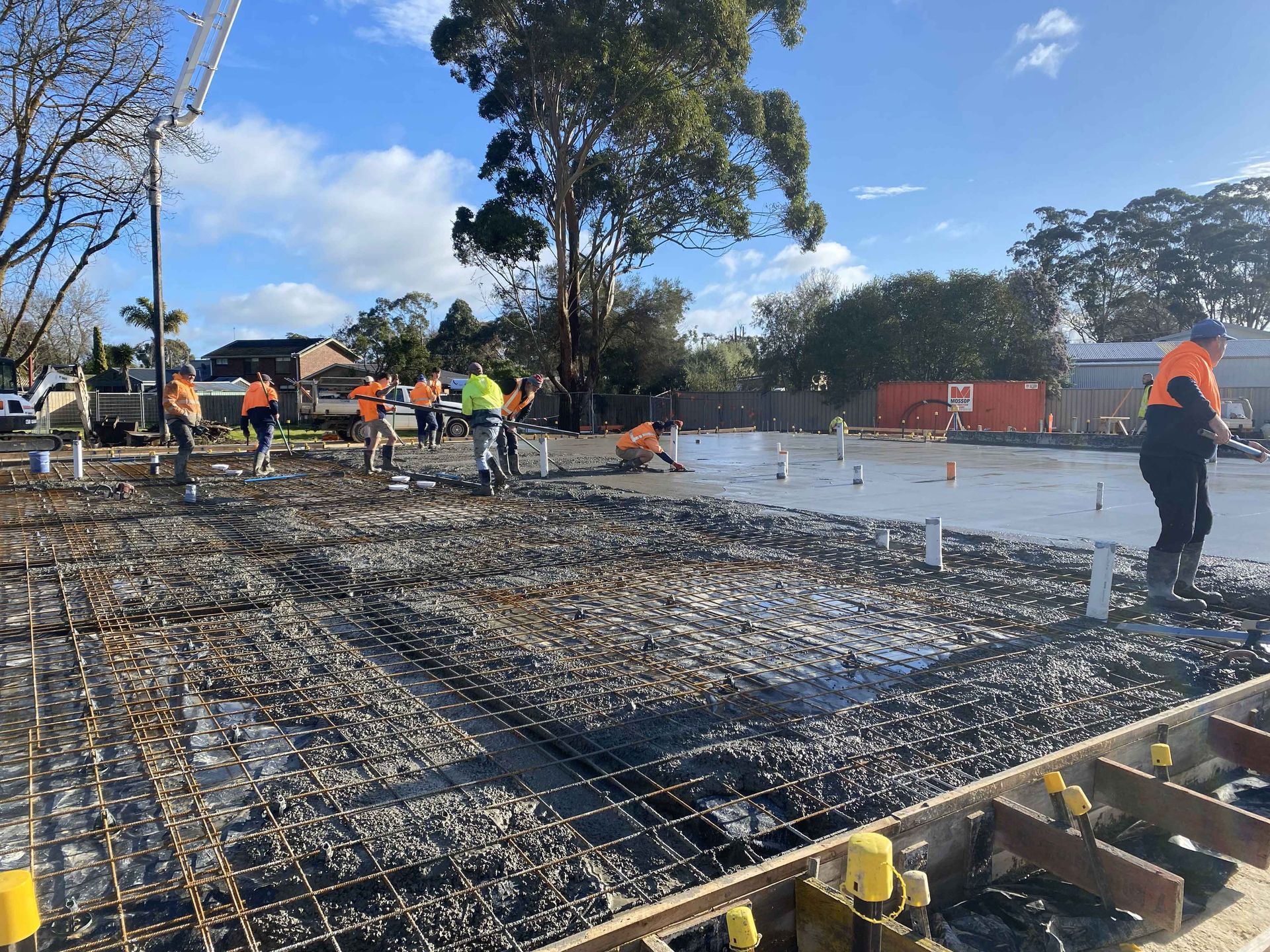 A group of construction workers are working on a muddy construction site.