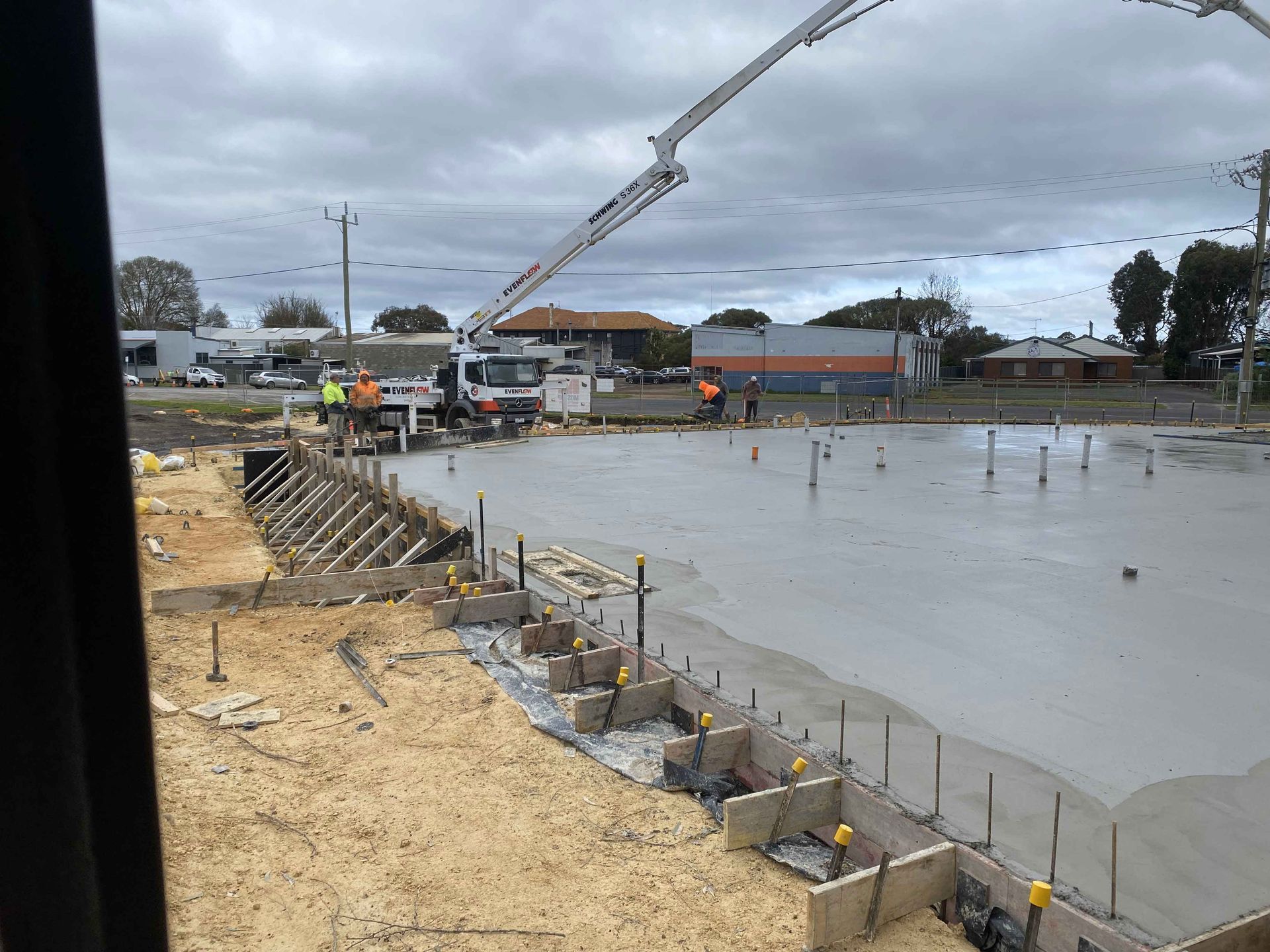 A large concrete slab is being poured on a construction site.