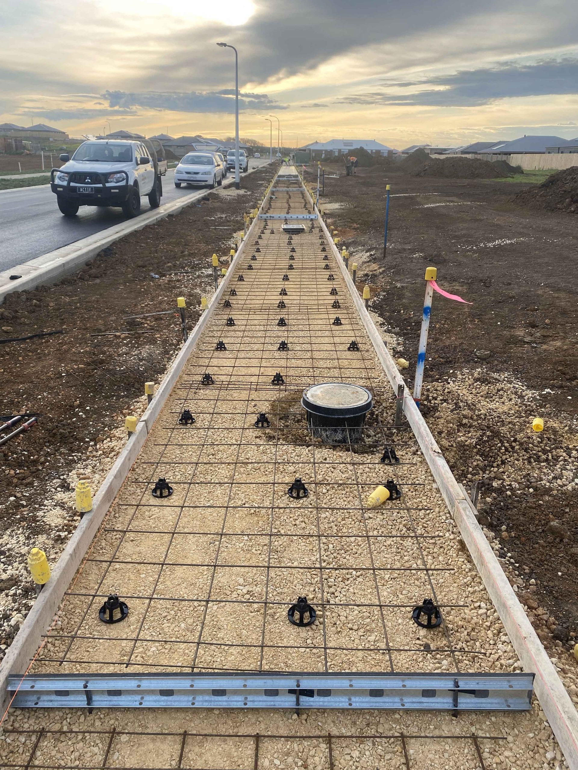 A concrete walkway is being built on the side of a road.