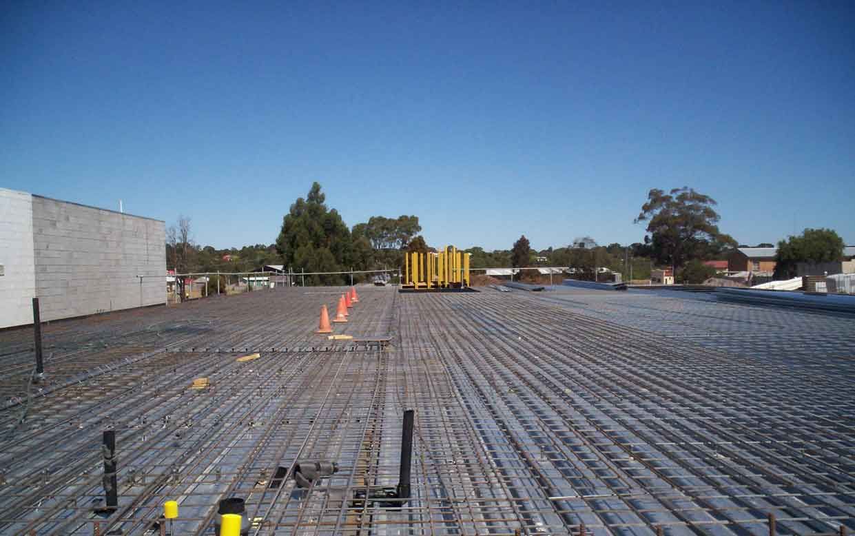 A roof is being built with a blue sky in the background.