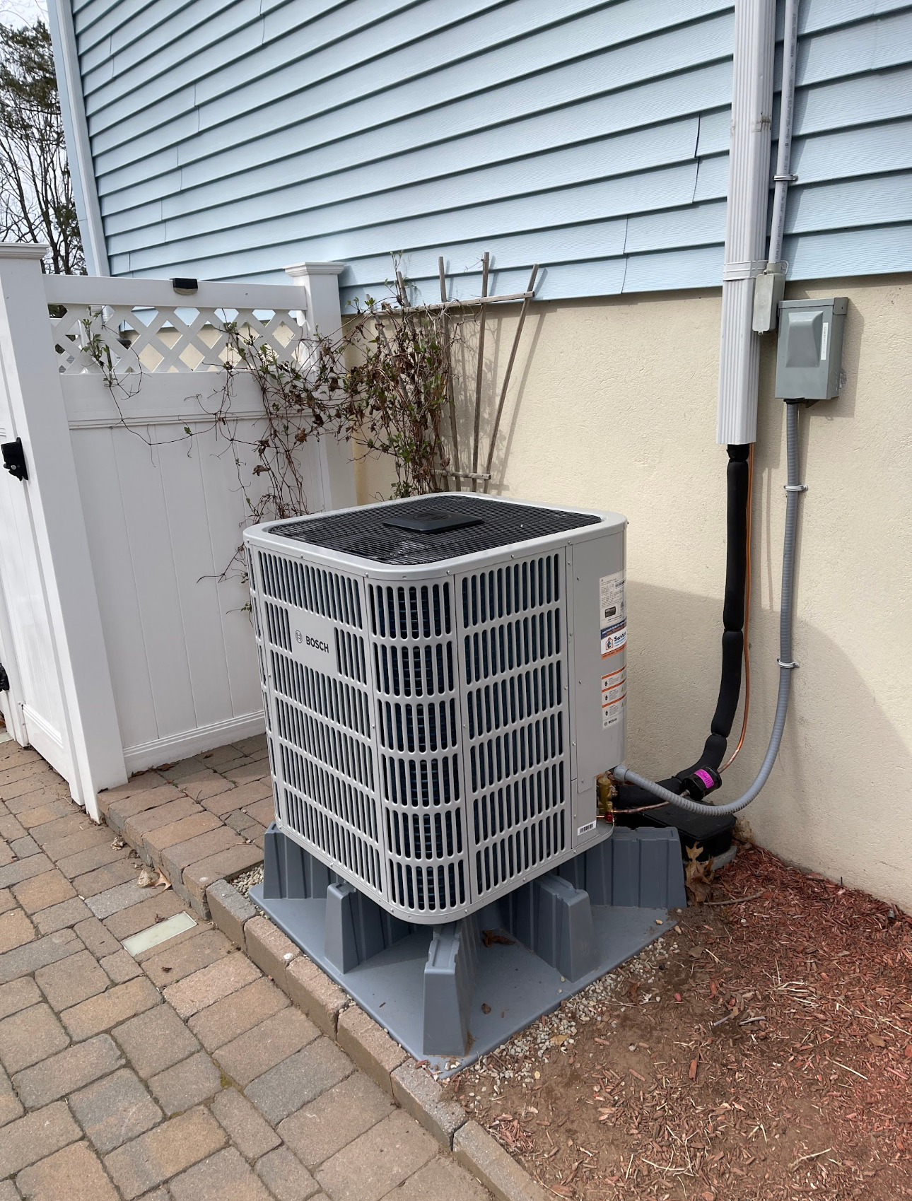 An air conditioner is sitting on the side of a house.