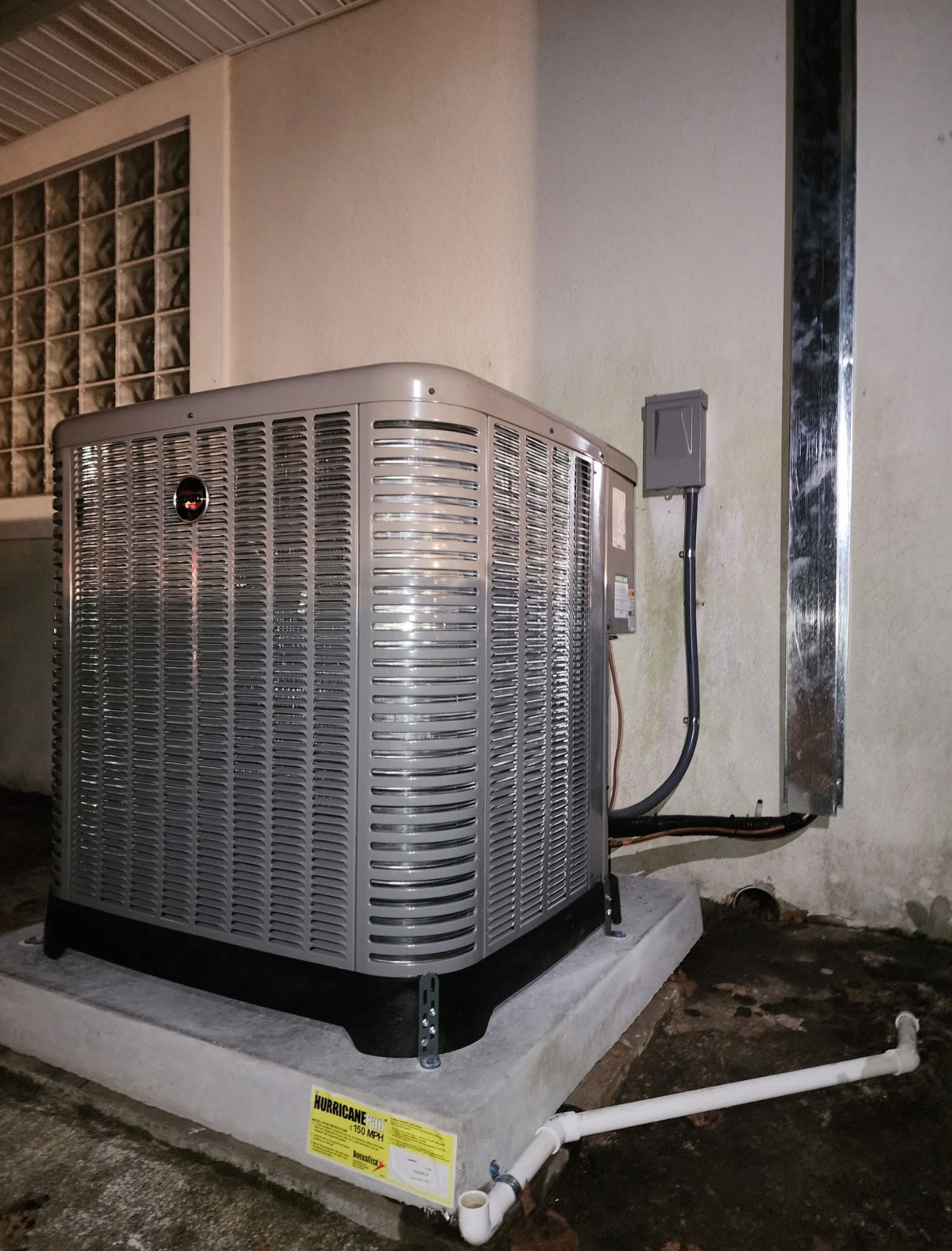 A large air conditioner is sitting on top of a concrete platform.