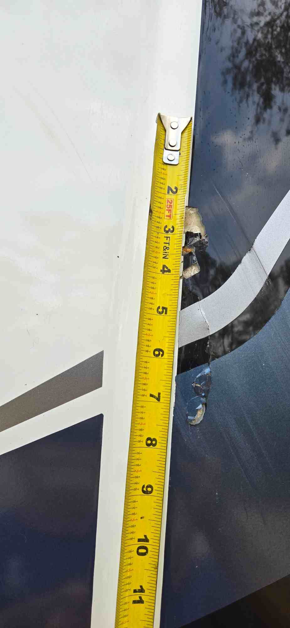 A yellow tape measure showing about 11 inches is placed next to a white surface.