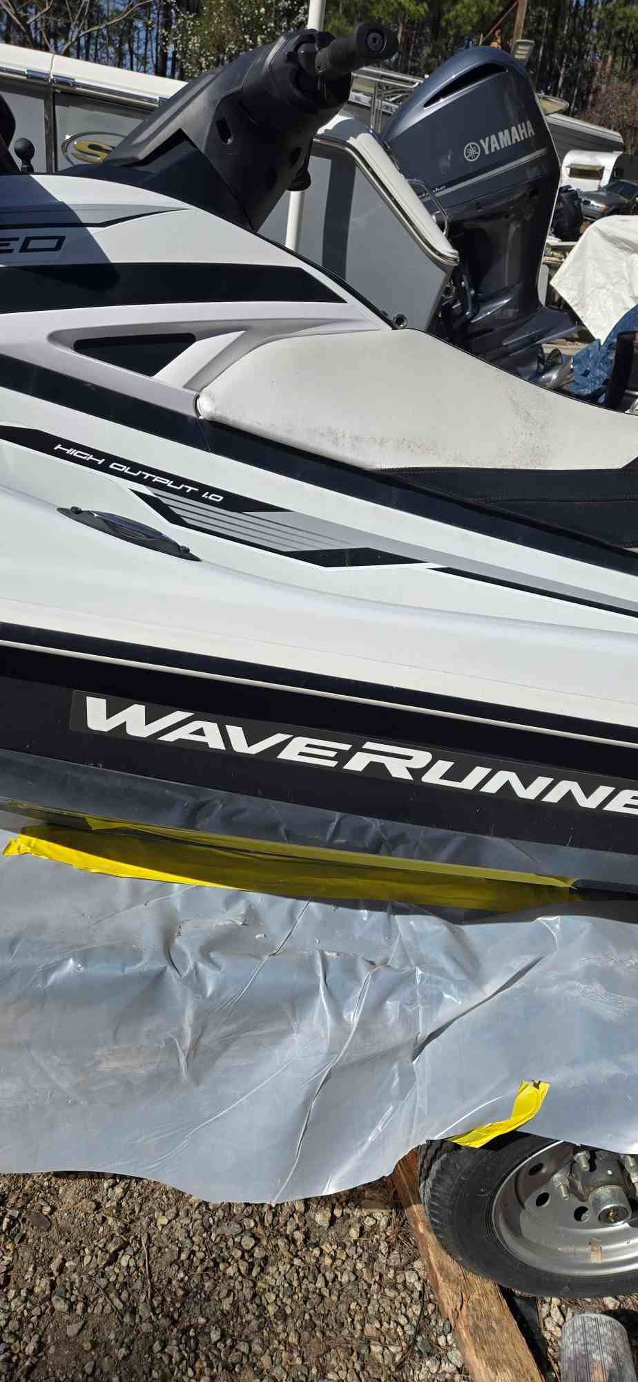 White and black WaveRunner on a trailer, covered with plastic.