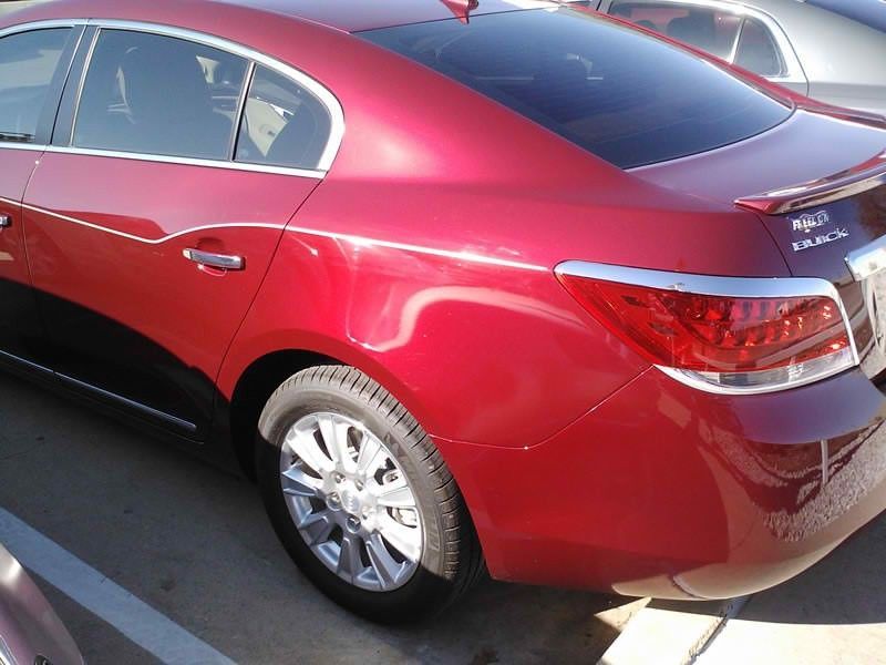 A red car is parked in a parking lot