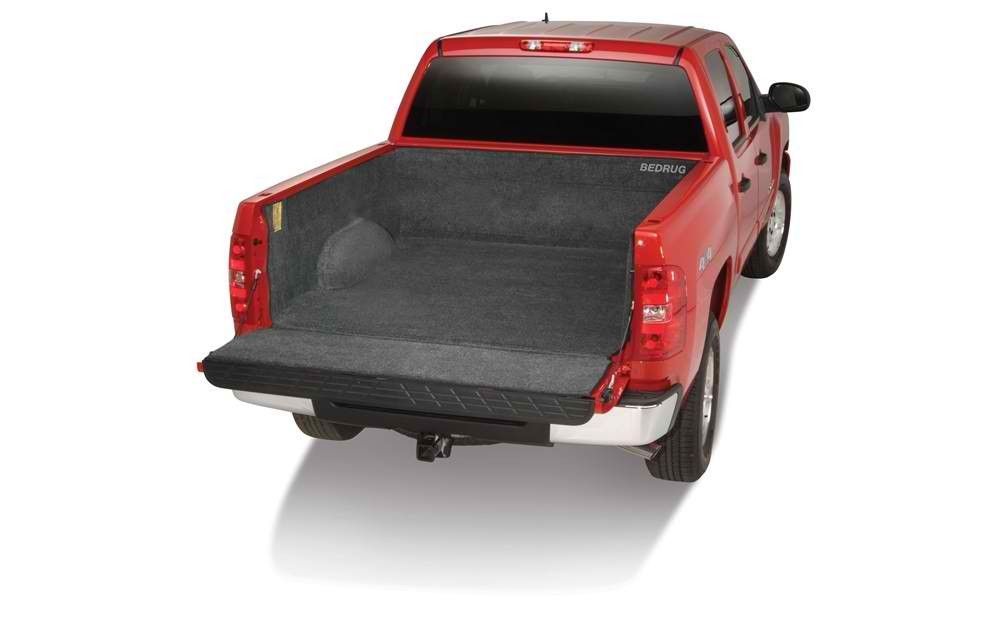 A red truck with a black bed mat in the bed