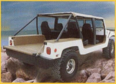 A white jeep is parked on a rocky beach near the ocean