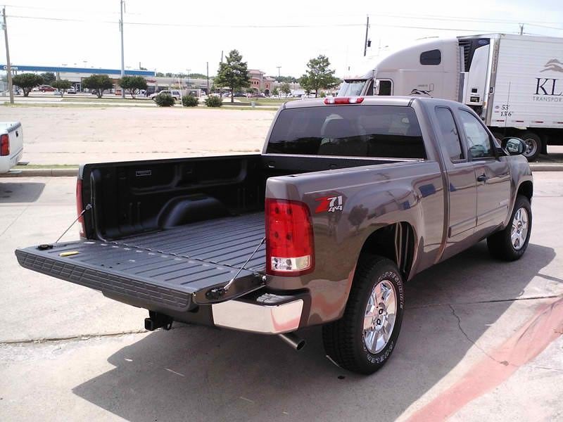 A pickup truck with the bed open is parked in a parking lot