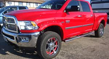 A red dodge ram truck is parked in a parking lot.