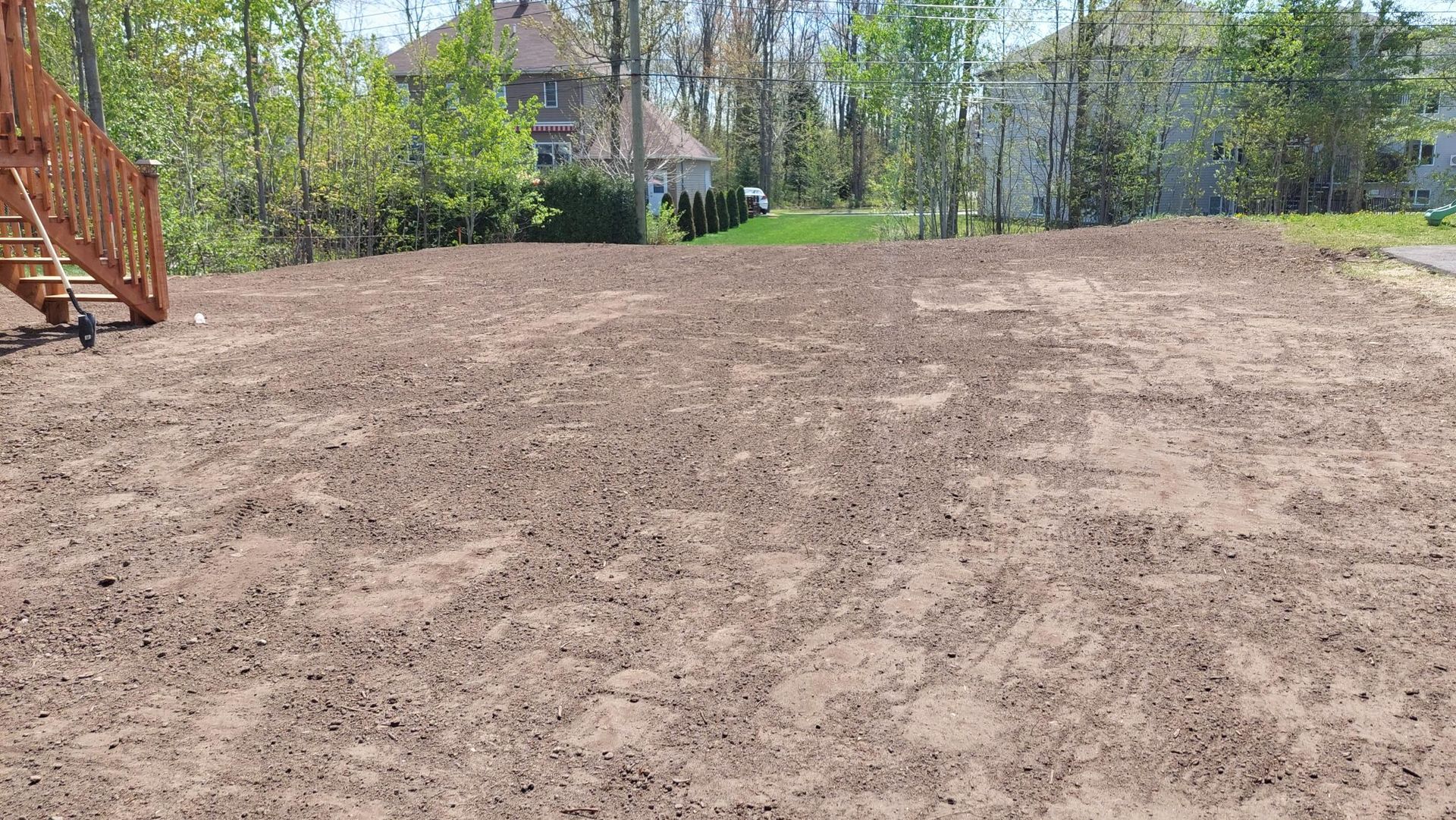 Un grand champ de terre avec des escaliers en arrière-plan et une maison en arrière-plan.