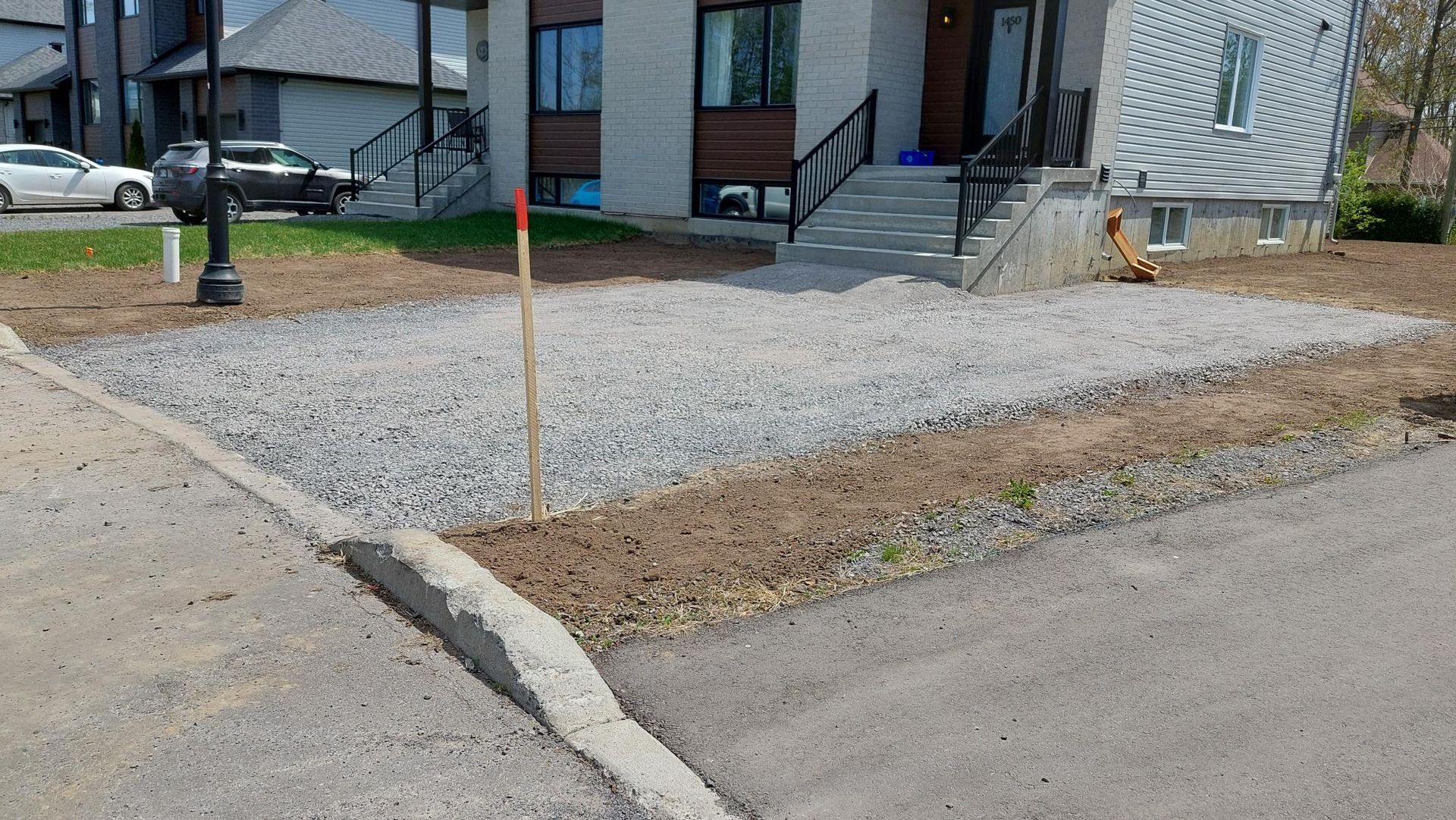 Une allée de gravier est en cours de construction devant une maison.