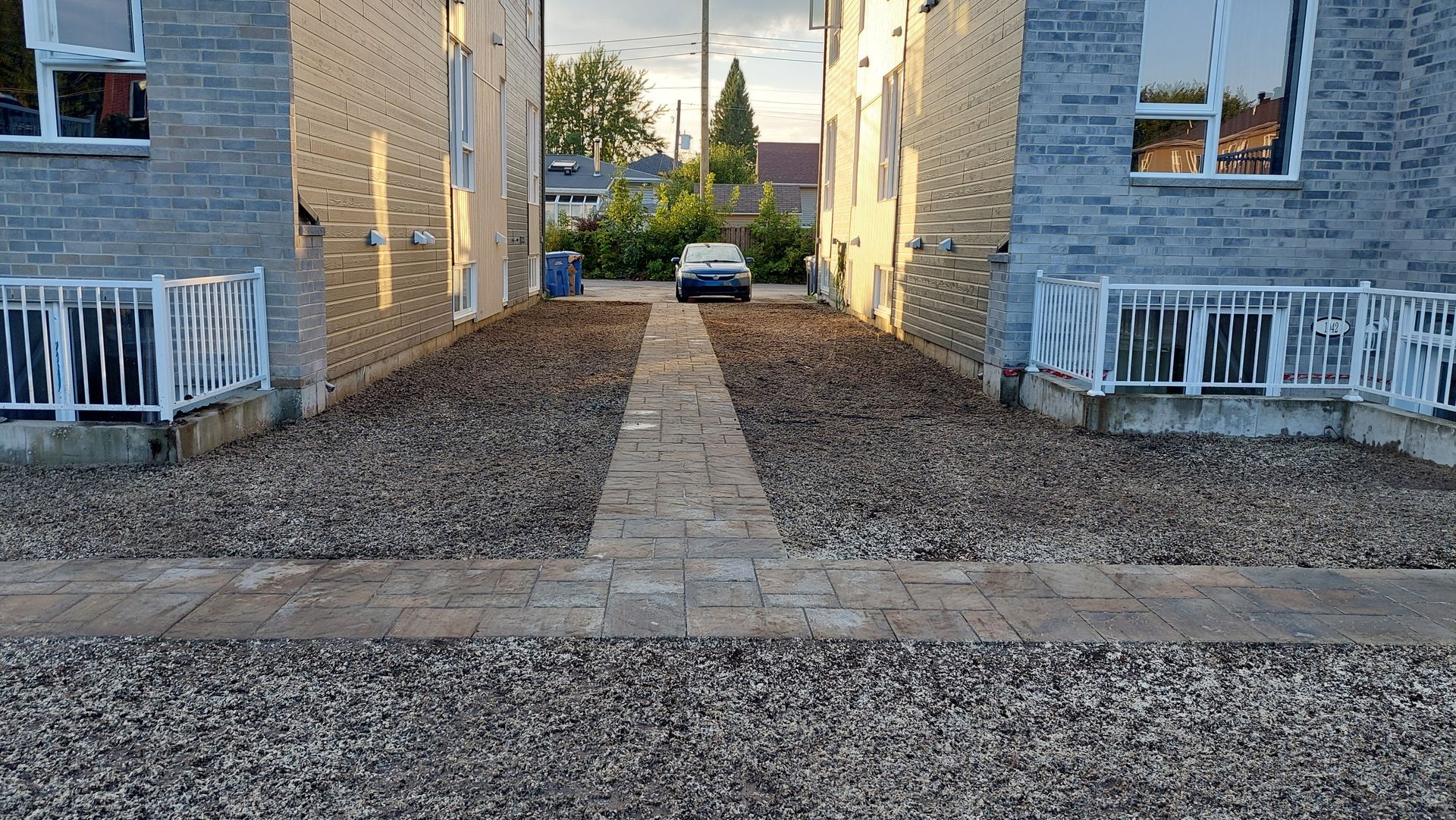 Une voiture est garée dans une allée entre deux bâtiments.