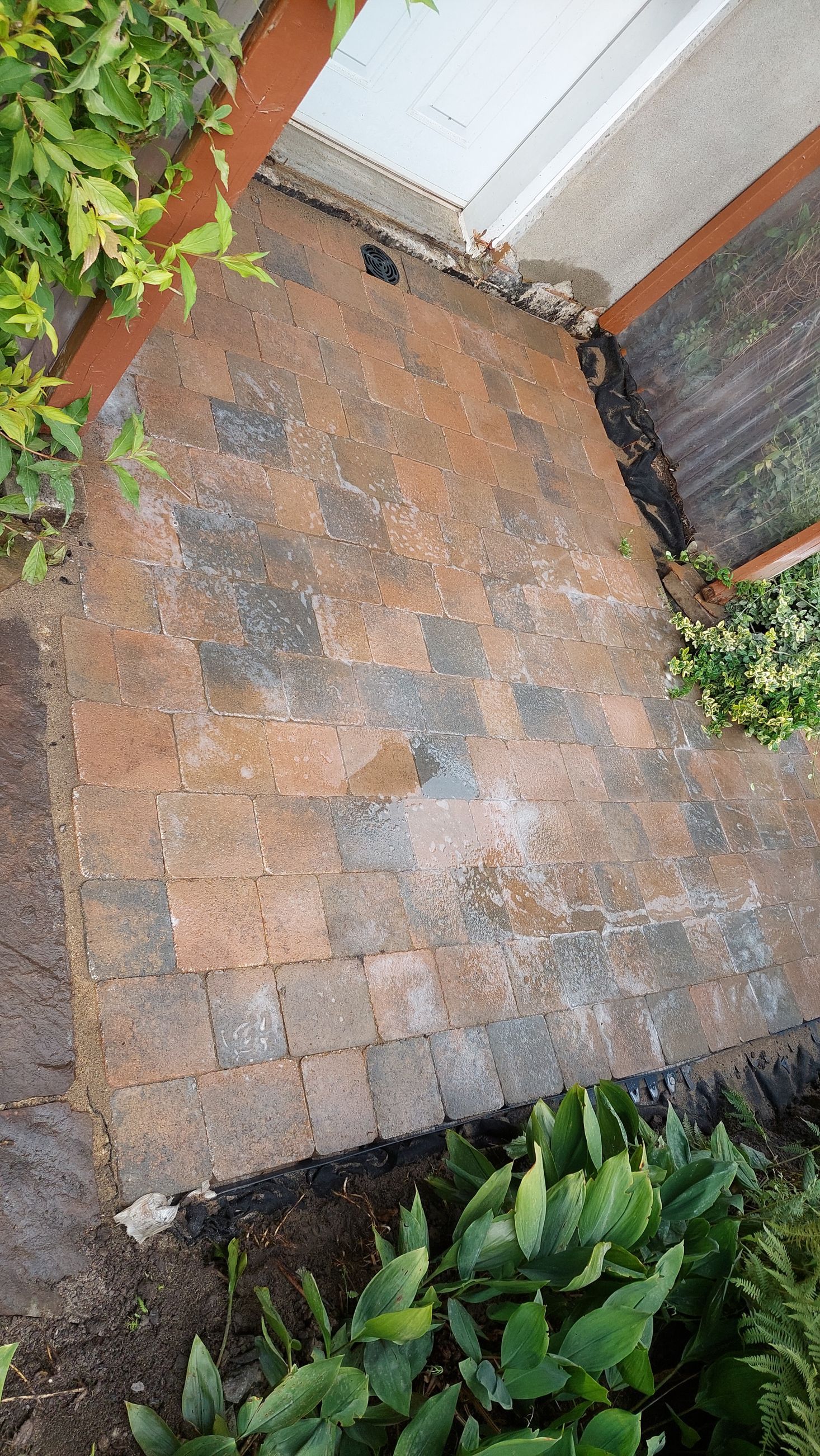 Une passerelle en briques est en cours de construction devant une maison.