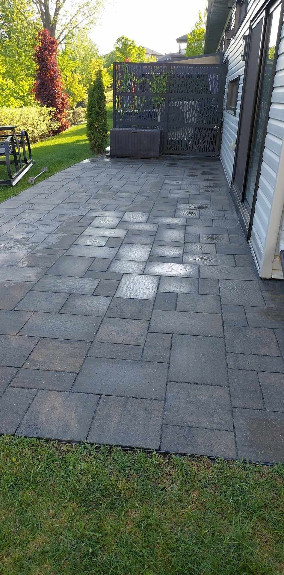 Un patio avec une balançoire et un banc devant une maison.