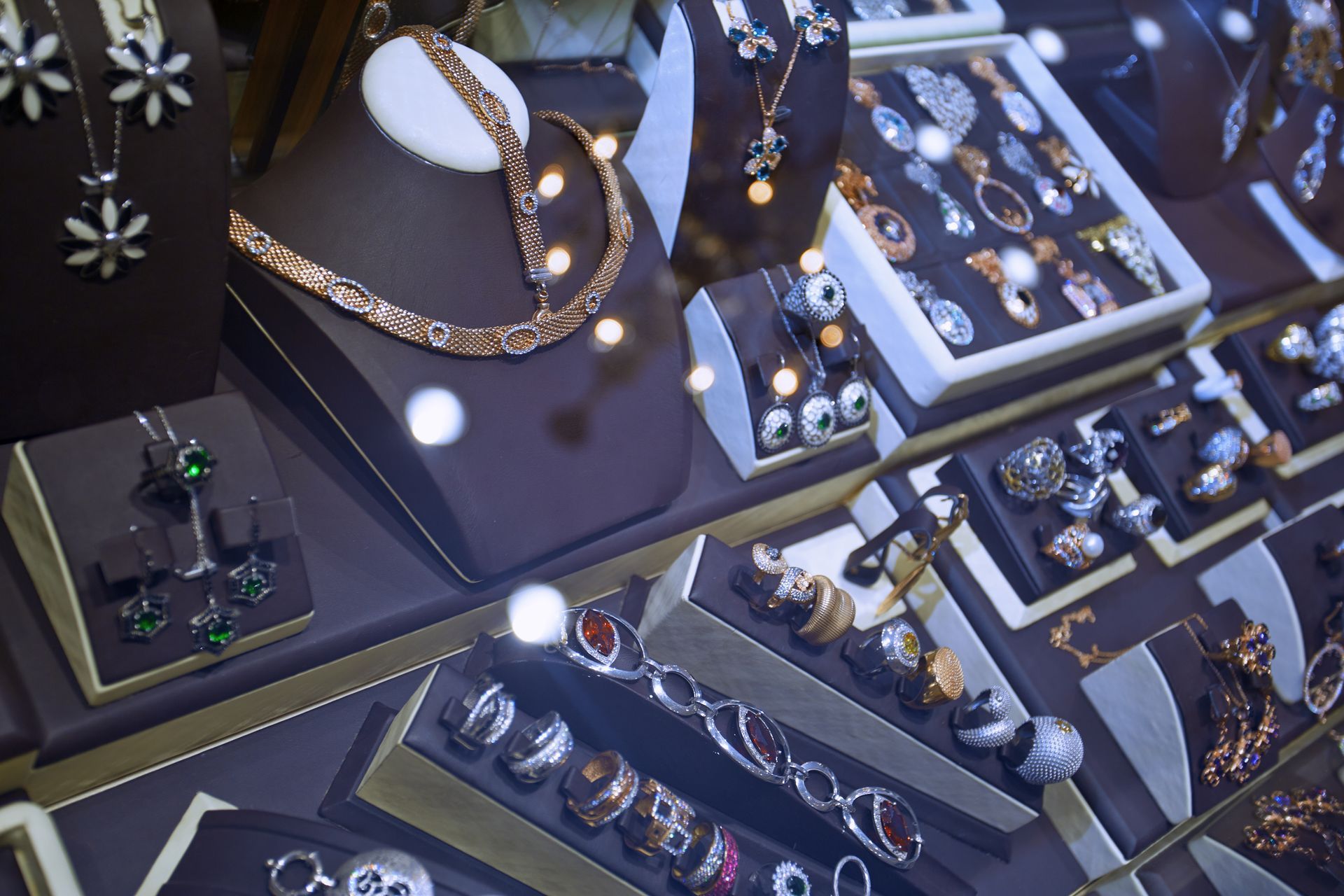 A woman is sitting at a table making jewelry.